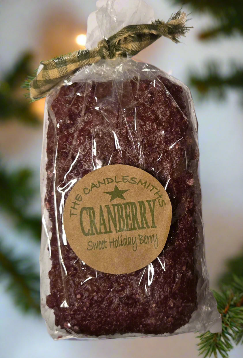 A Cranberry Loaf Candle packaged in a clear plastic bag with a label that reads 'The Candlesmith - The Cranberry'.