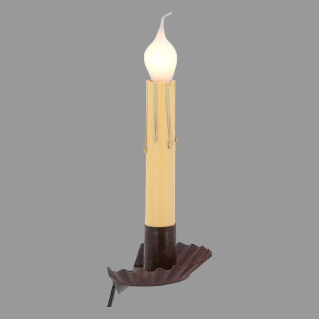 A rustic tin window sill light with a visible wax candle top and a brown base, designed to be placed on a window sill.
