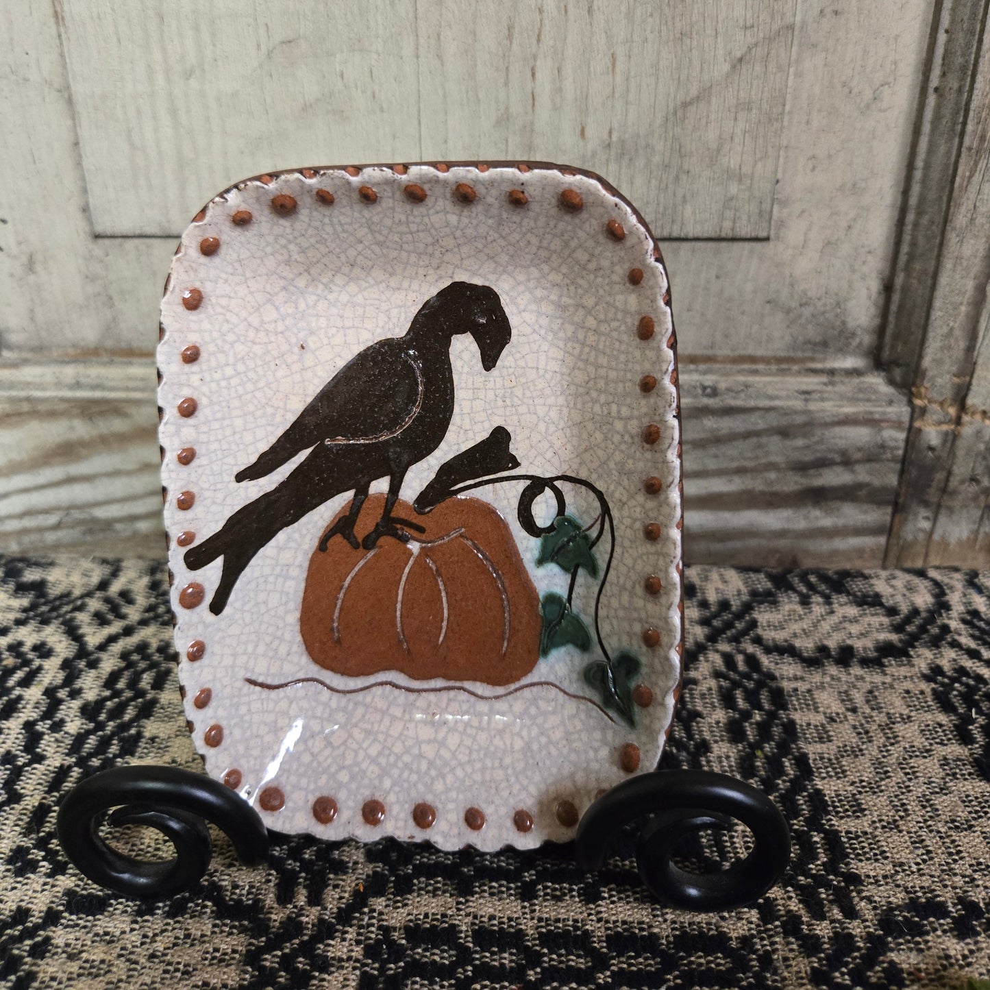 Small rectangular redware plate featuring a crow sitting on a pumpkin on the vine