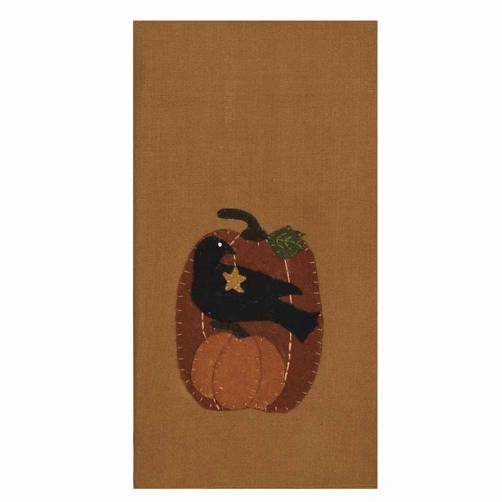 A hand towel with a crow perched on a pumpkin design, primarily in brown and black colors.