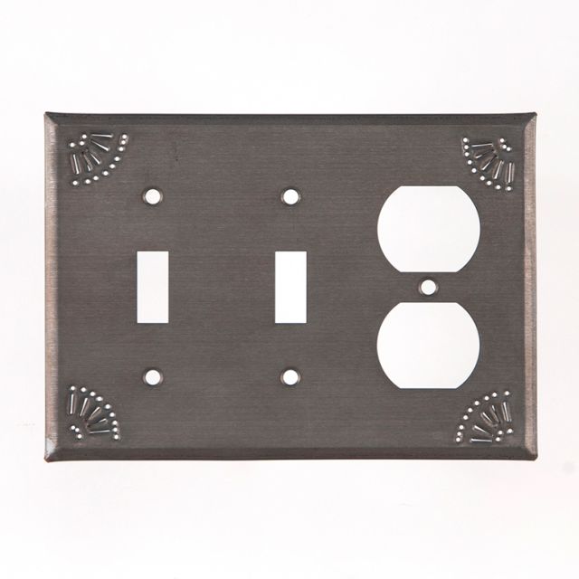 A black tin double switch and outlet cover with chisel marks around the edge.