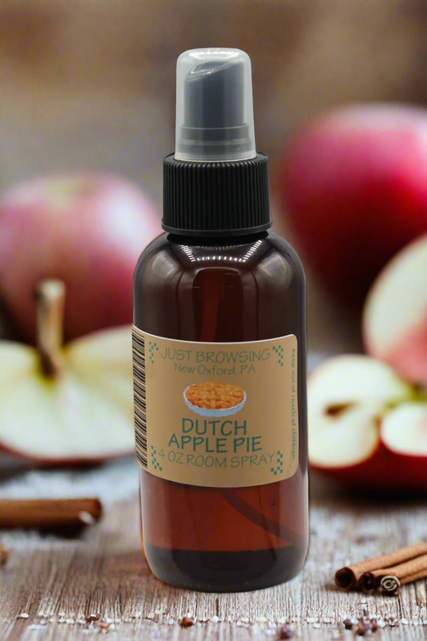 Room spray bottle labeled 'Dutch Apple Pie' with apples and cinnamon sticks in the background