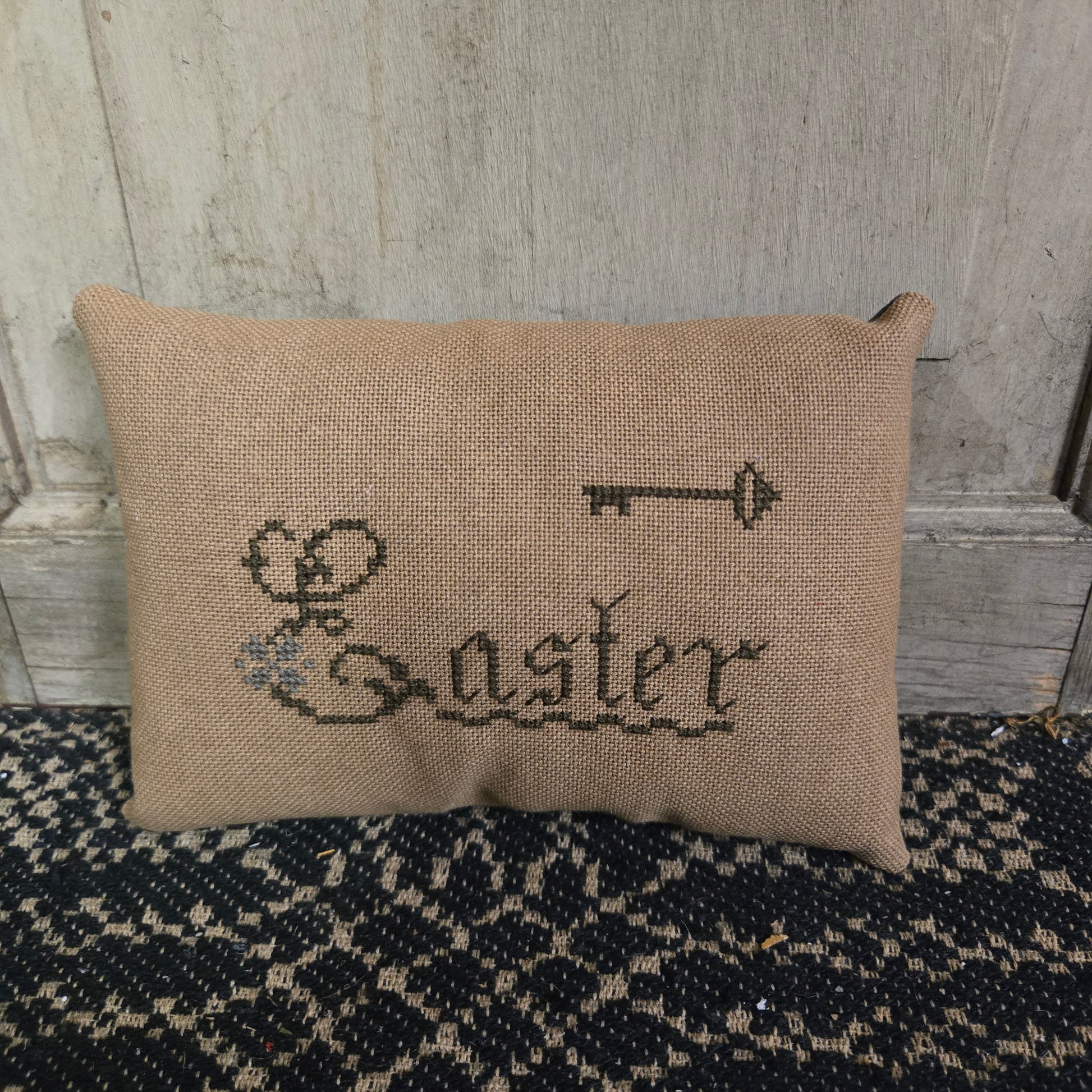 Rectangular cross stitch pillow with the word 'Easter' and a key
