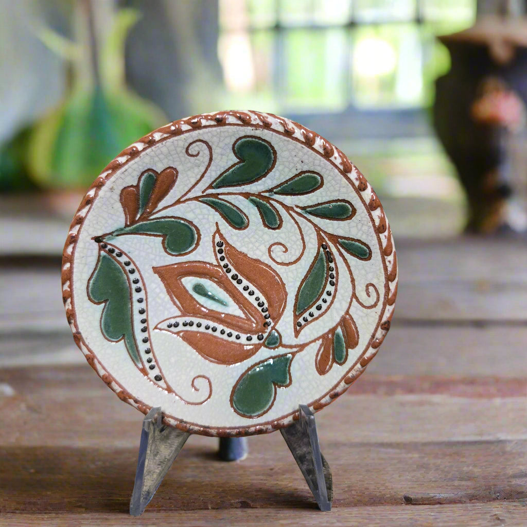 Small round redware plate with an intricate tulip design