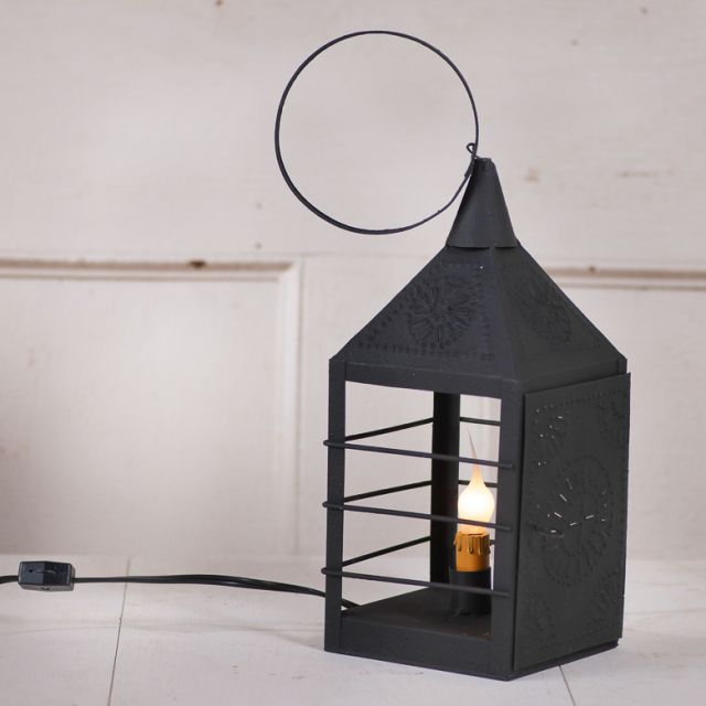 Black decorative lantern with a light bulb inside on a white background