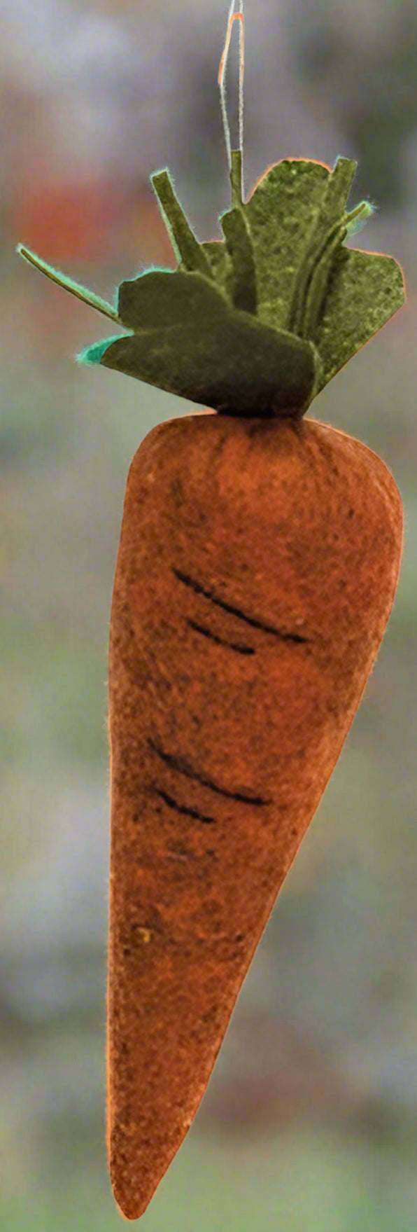 A stuffed felt carrot with hand-stitched markings and a green, leafy top.