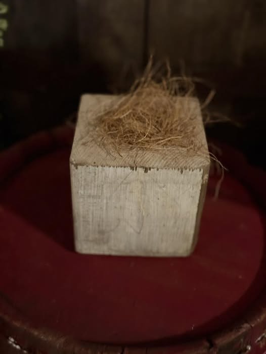 Wooden block with straw on a red surface