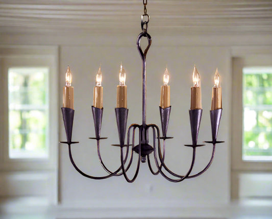 A wrought iron chandelier with six lights, featuring a dark color and a classic design.