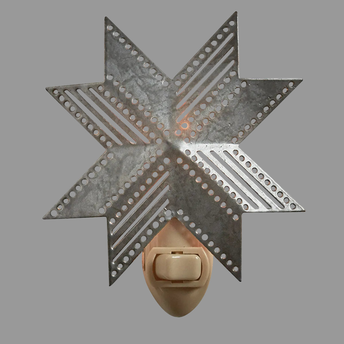 A metal night light in the shape of a folk star with a pull chain switch, mounted on a wall.