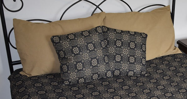 Patterned pillows on a bed with a black metal headboard