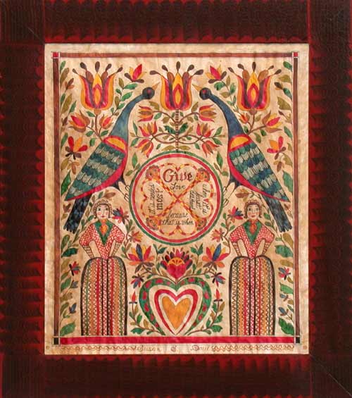 A framed artwork featuring a circular design with the text 'GIVE' in the center, surrounded by colorful bird and floral patterns, and figures wearing traditional clothing.