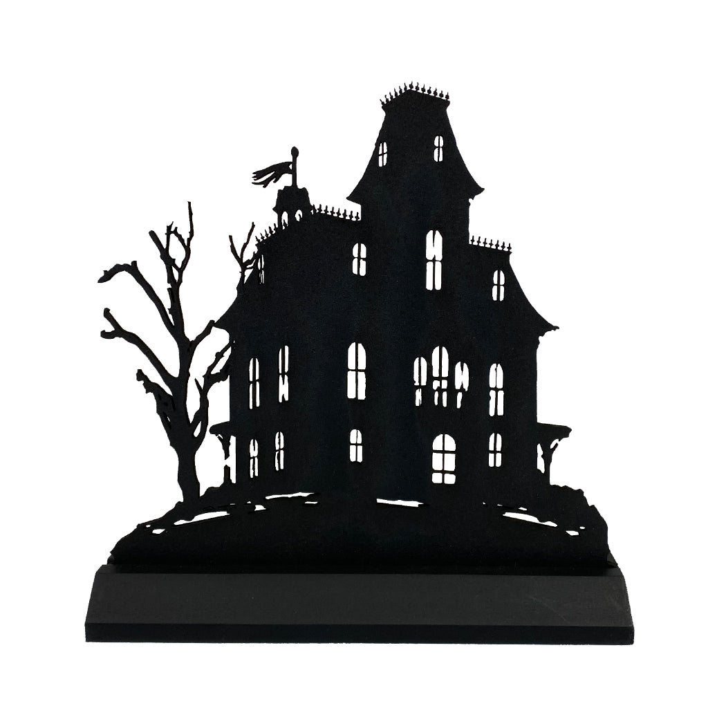 Black silhouette of a haunted house with bare trees on a white background