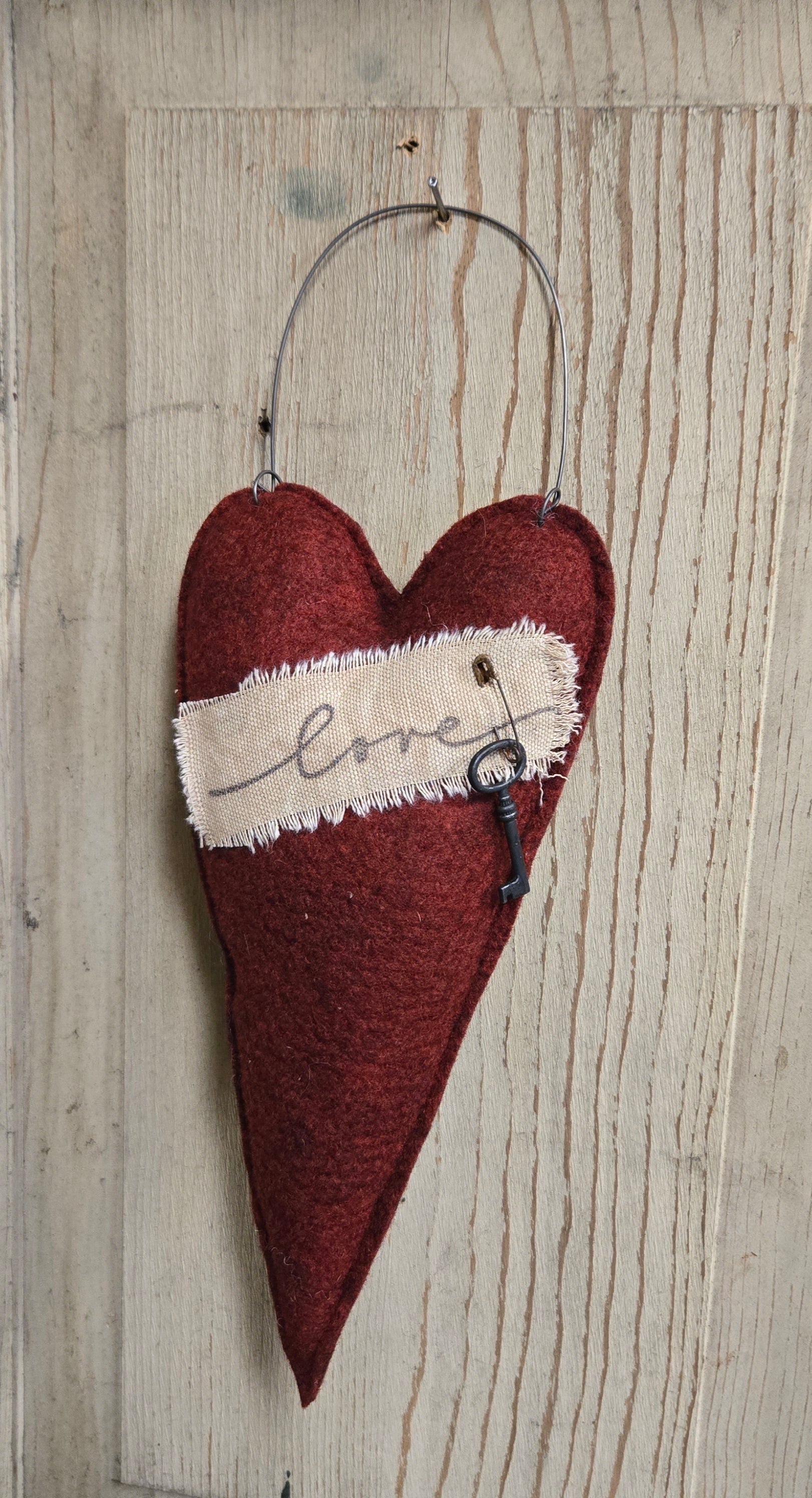 Heart-shaped decorative item with a key and 'love' text on a wooden background