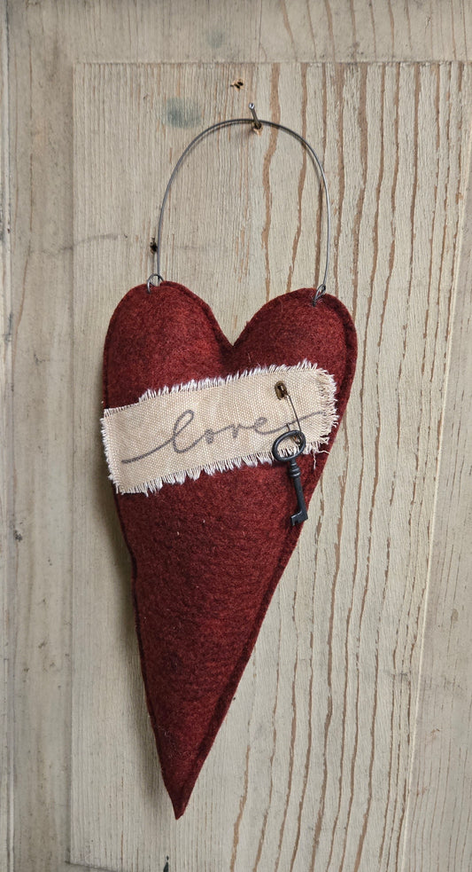Heart-shaped decorative item with a key and 'love' text on a wooden background