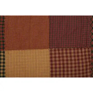 A close-up of a patchwork fabric design featuring six distinct gingham and checkered squares in warm autumn tones of red, brown, beige, and green.