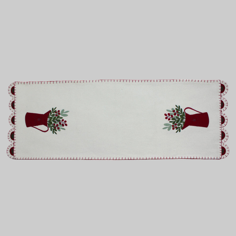 A cream-colored table runner with a pitcher design and red trim, suitable for holiday dining tables.