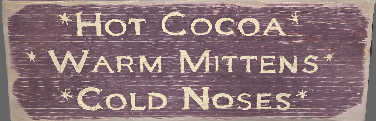 Weathered red wood sign with words advertising hot cocoa