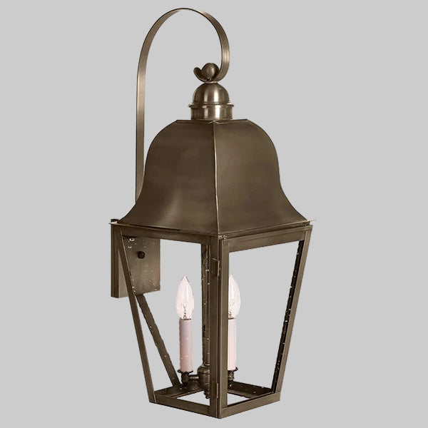 Bronze outdoor wall lantern with two candle-like lights on a gray background