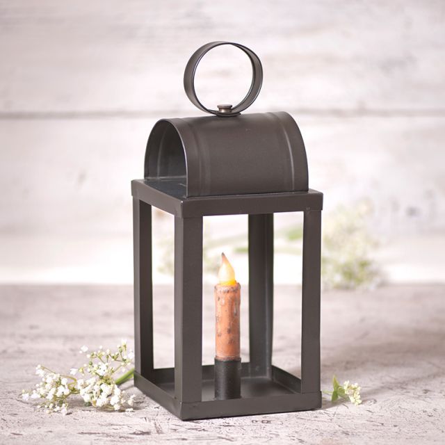 Primitive keeping room lantern in smokey black finish with flowers in background.