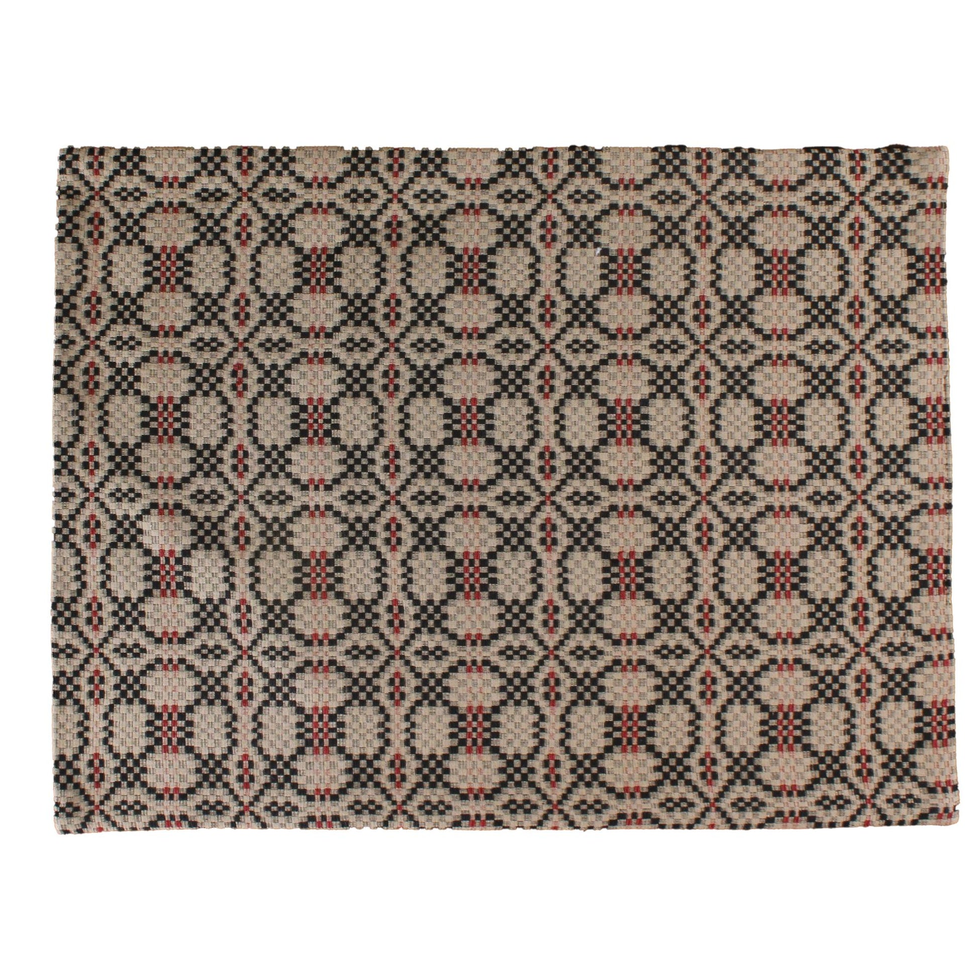 A black placemat with an intricate geometric jacquard design, featuring a repeating pattern of diamonds and other geometric shapes on a textured background.