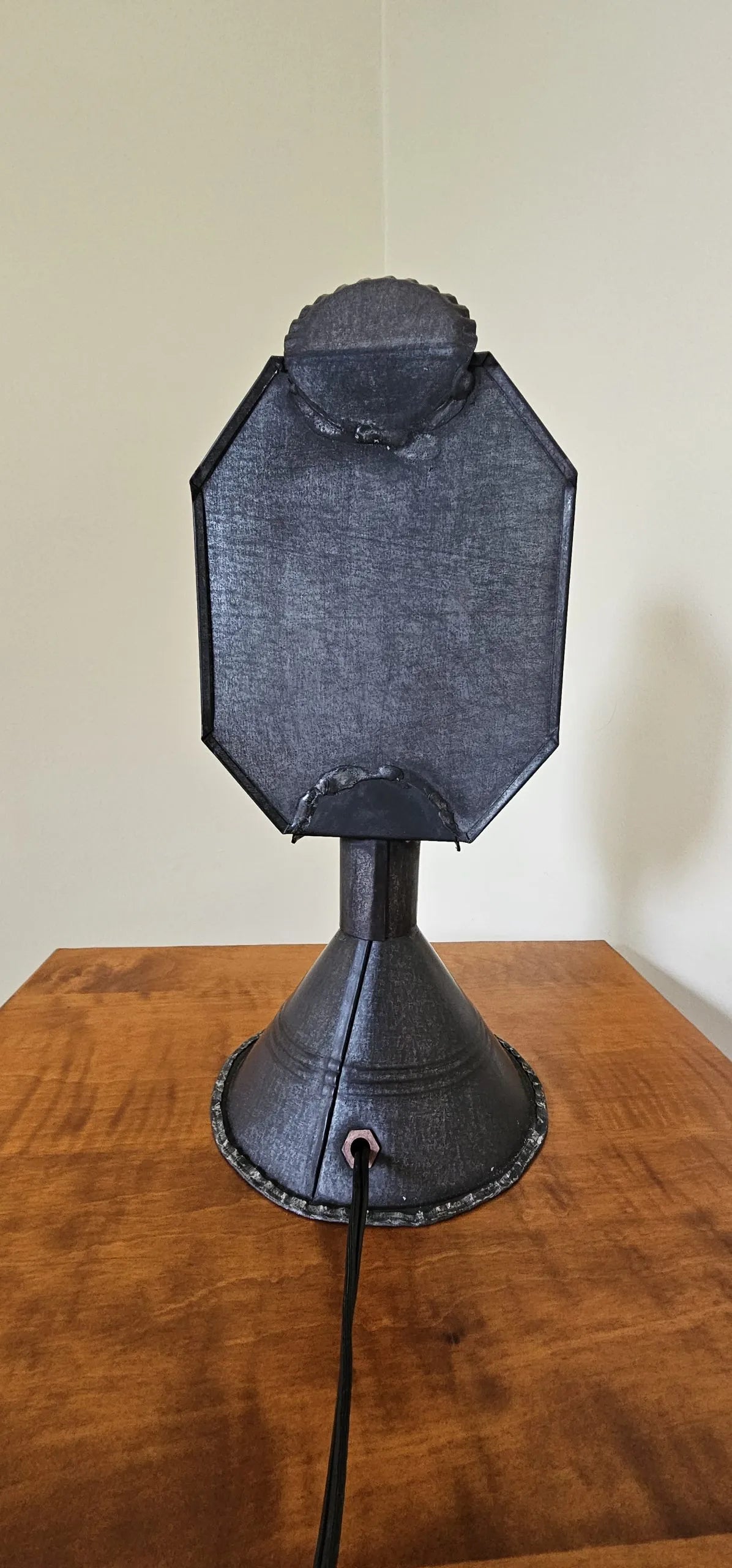 Black octagonal softbox on a stand against a white wall