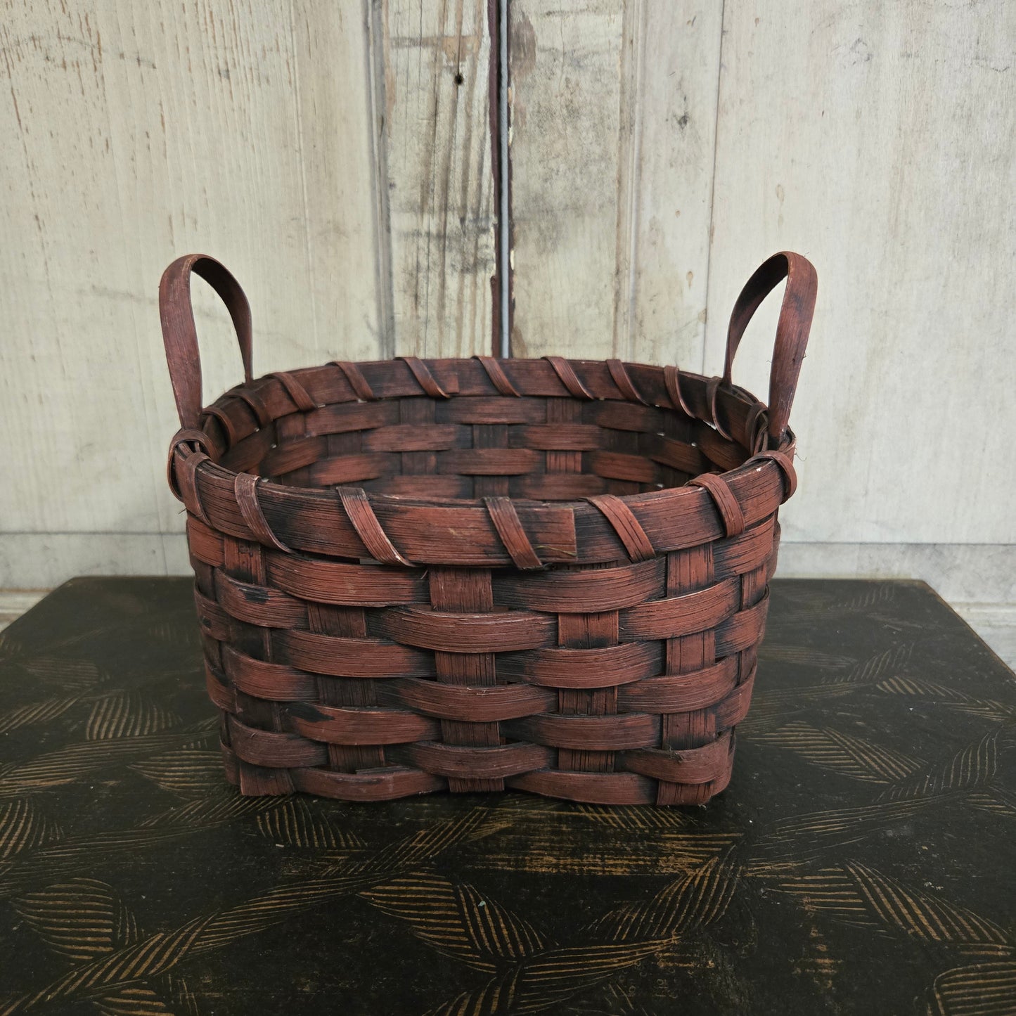 Woven burgundy basket on a textured surface
