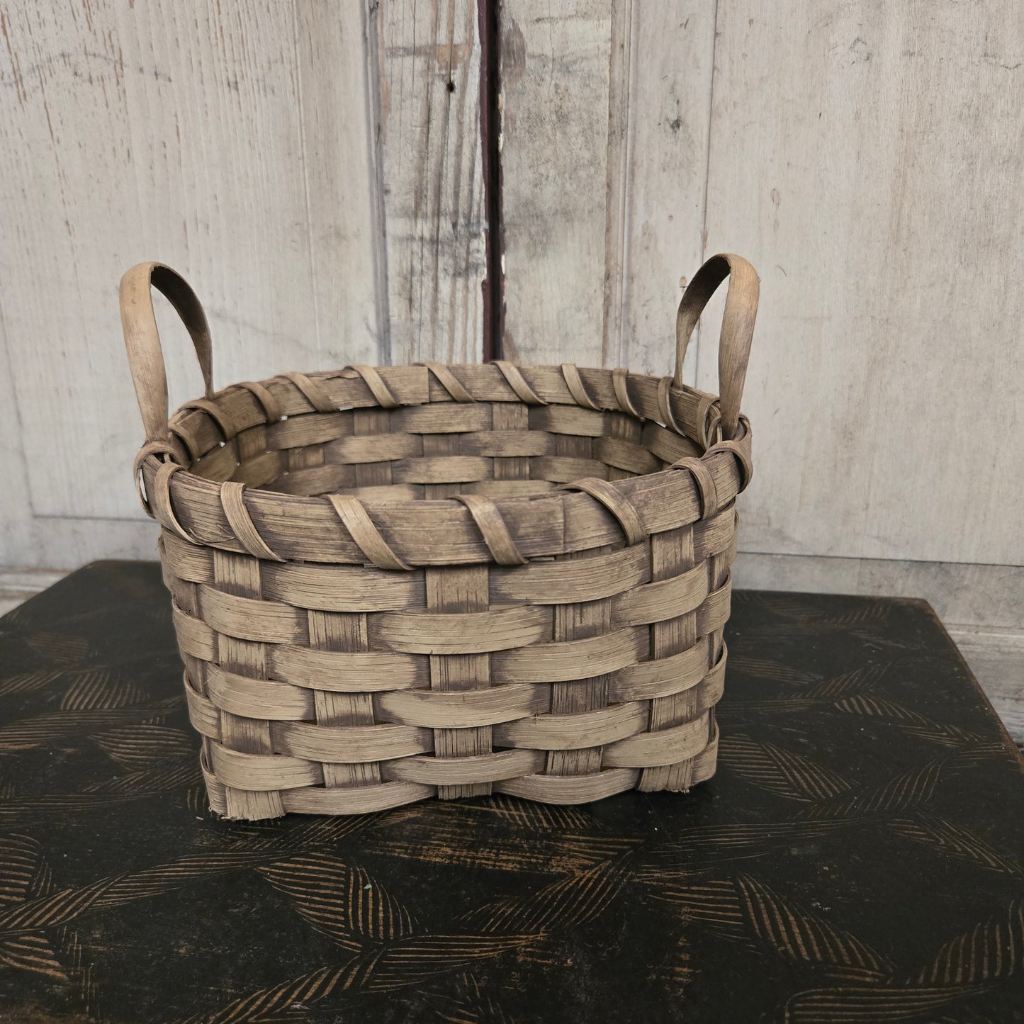 Woven basket with a handle on a textured surface