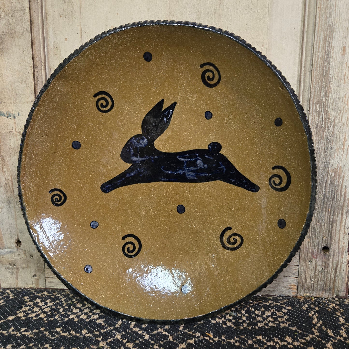 Round brown plate with bunny design on against a wooden surface