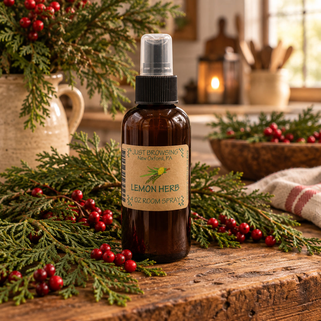 A 4oz bottle of Lemon Herb Room Spray with a mist spray top, labeled as 'Just Browsing' brand product surrounded by lemons and herbs.