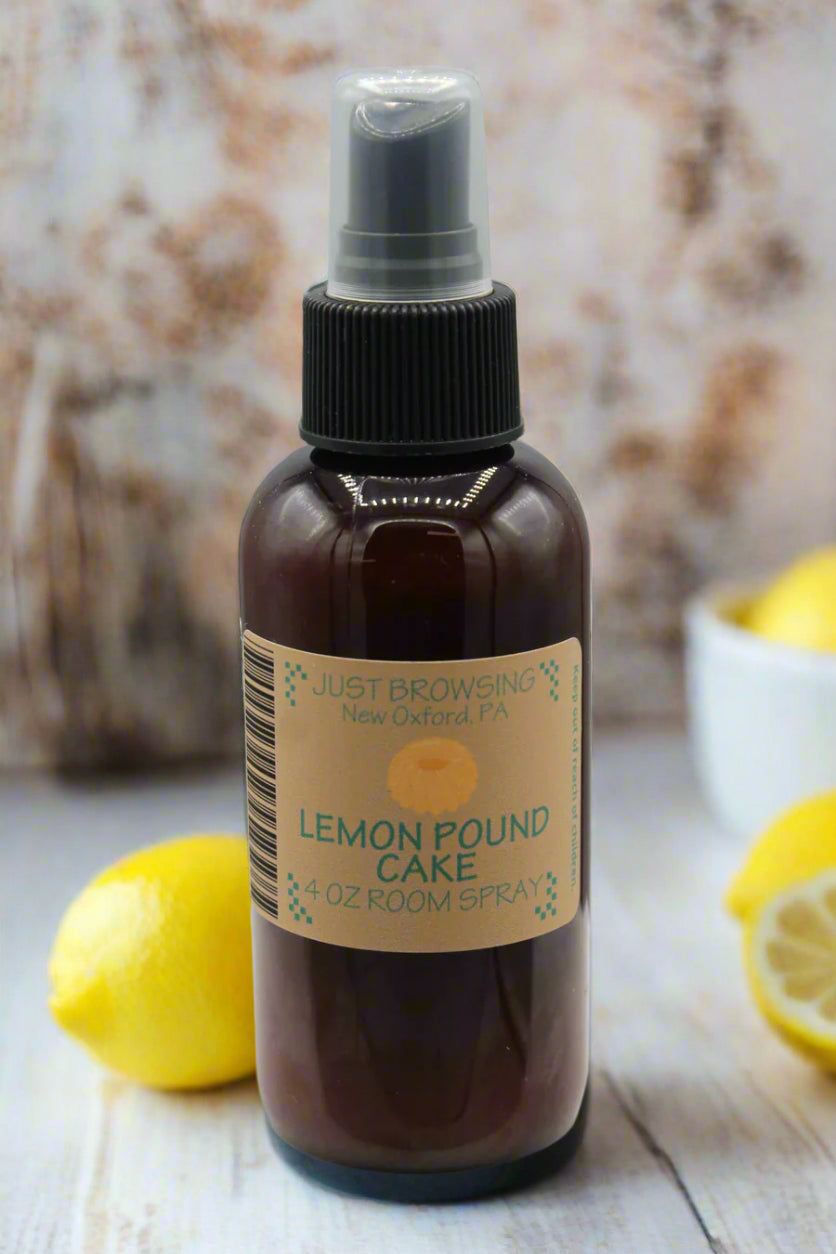 Brown spray bottle labeled 'Lemon Pound Cake' on a gray background surrounded by lemons