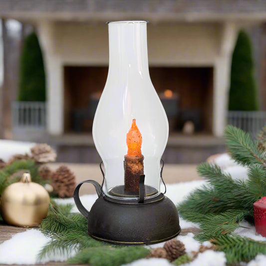 A smoky black tin library lantern with a strap metal handle and a glass chimney, featuring a battery-operated LED candle inside.
