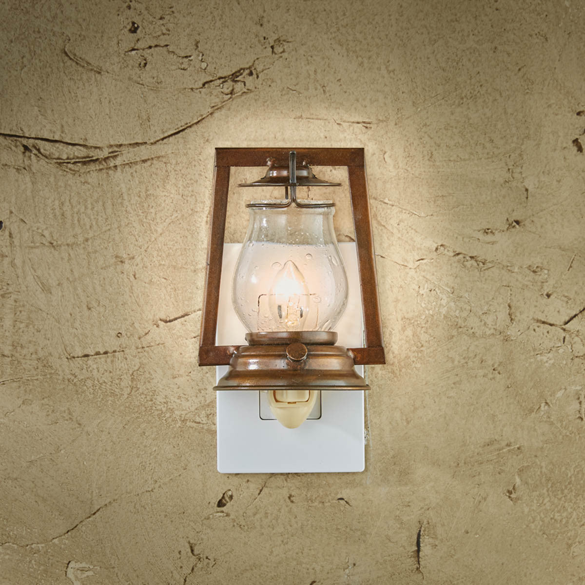 A mounted Lumberton night light with a clear glass globe and a brown wooden frame, illuminated and mounted on a wall.