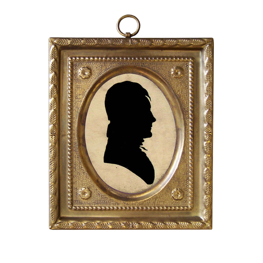 A brass framed miniature silhouette of a man with a fabric backing, suspended by a loop.
