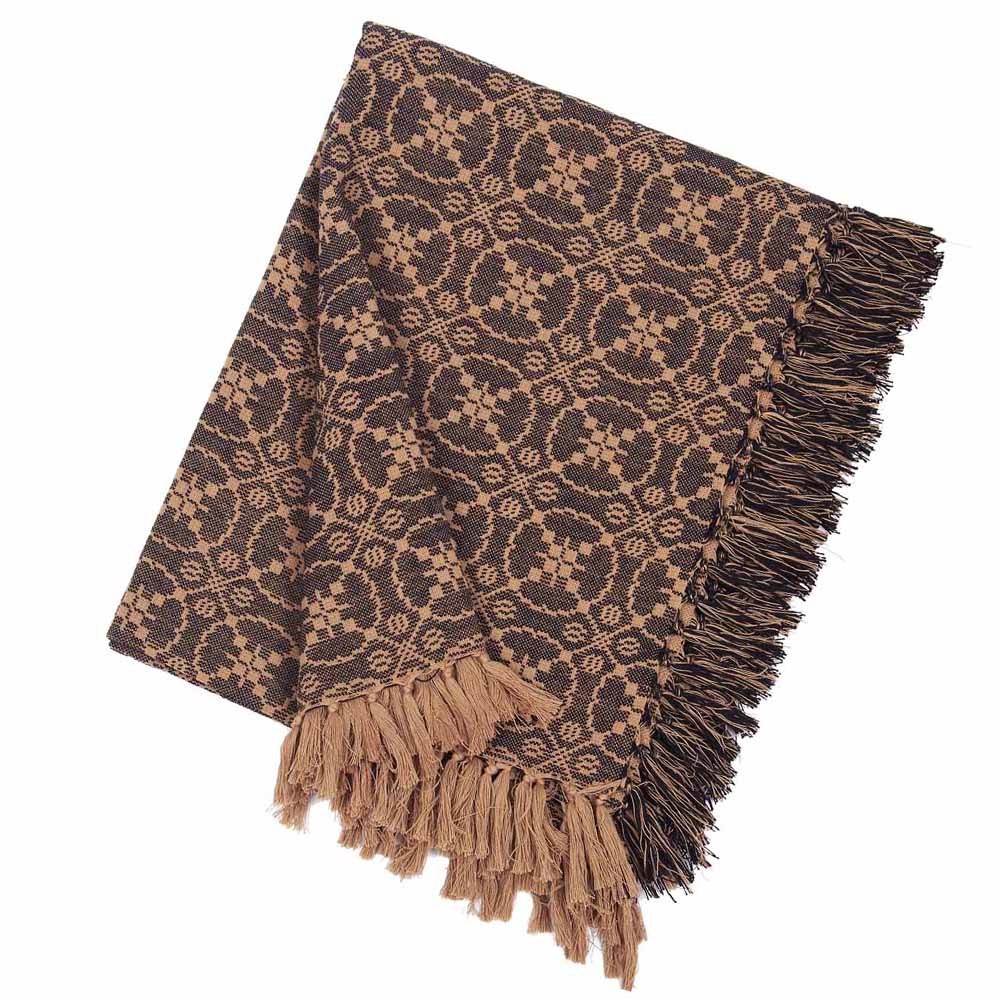 A jacquard woven afghan in black with geometric patterns and fringed ends.