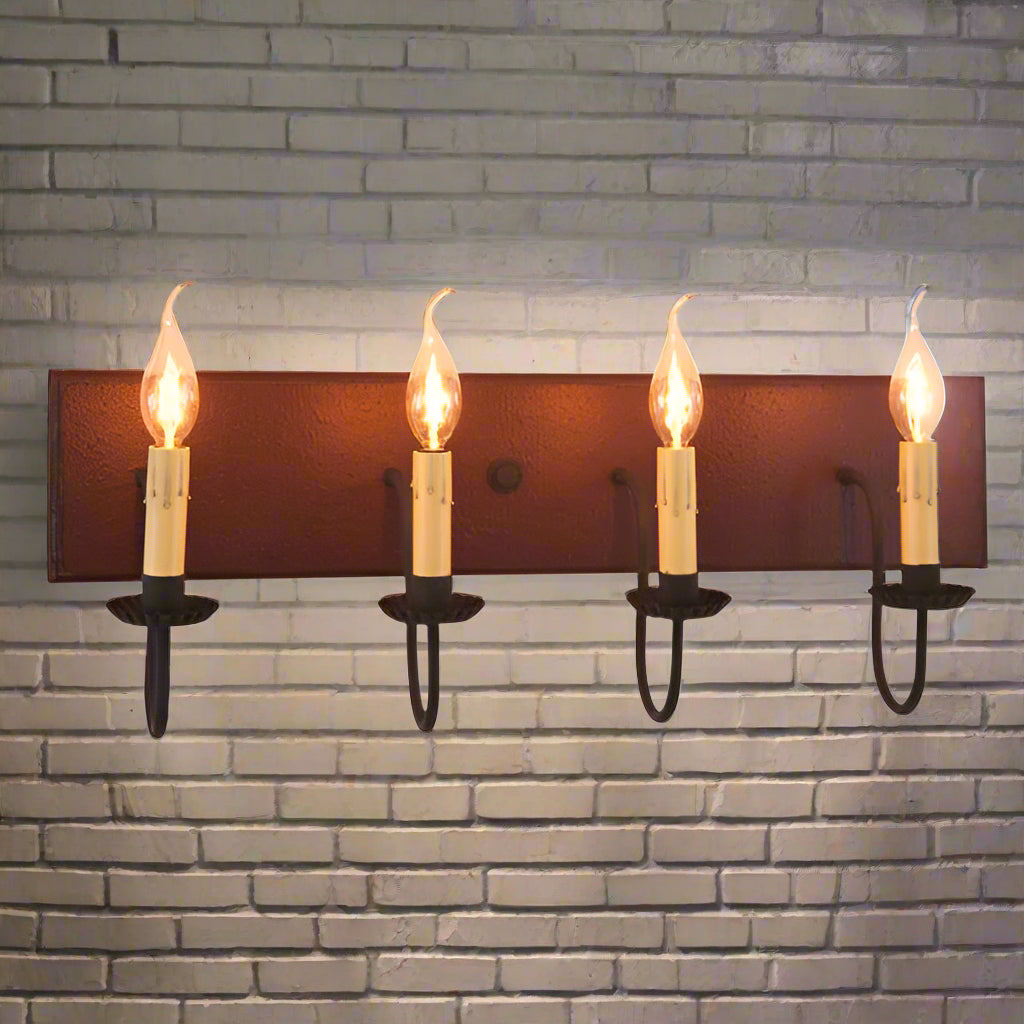 A red four-light vanity light fixture with textured black arms and crimped pans, handcrafted in Pennsylvania.