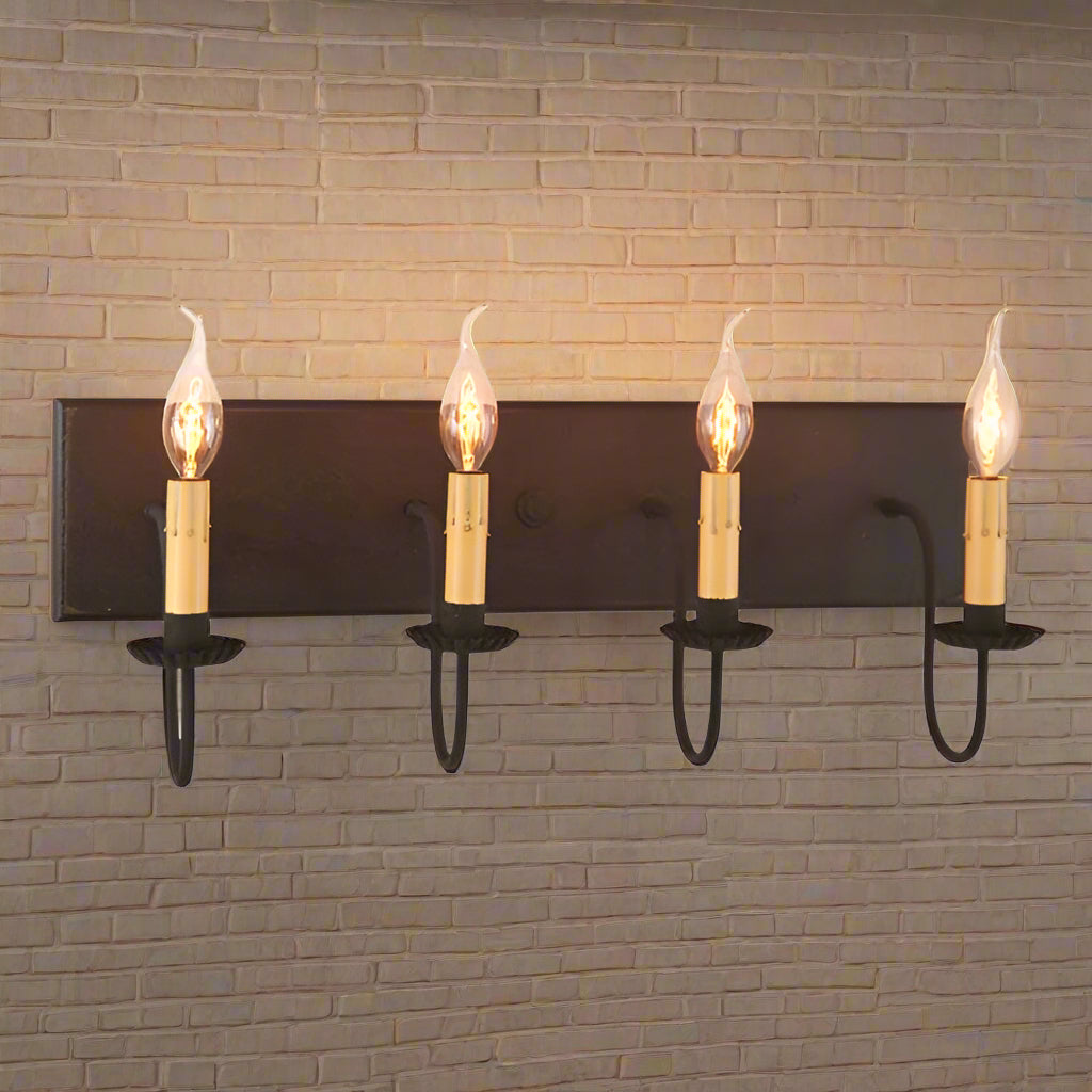 A traditional black vanity light with four exposed bulb sockets, hanging horizontally.