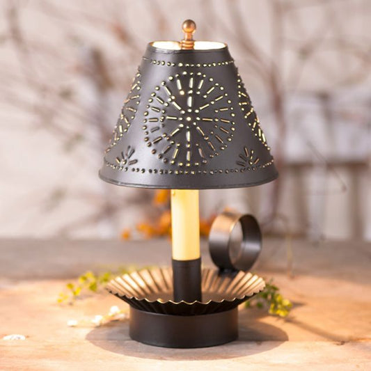 A medium crimped accent light with a smokey black finish and a punched tin shade, displayed against a blurred background.