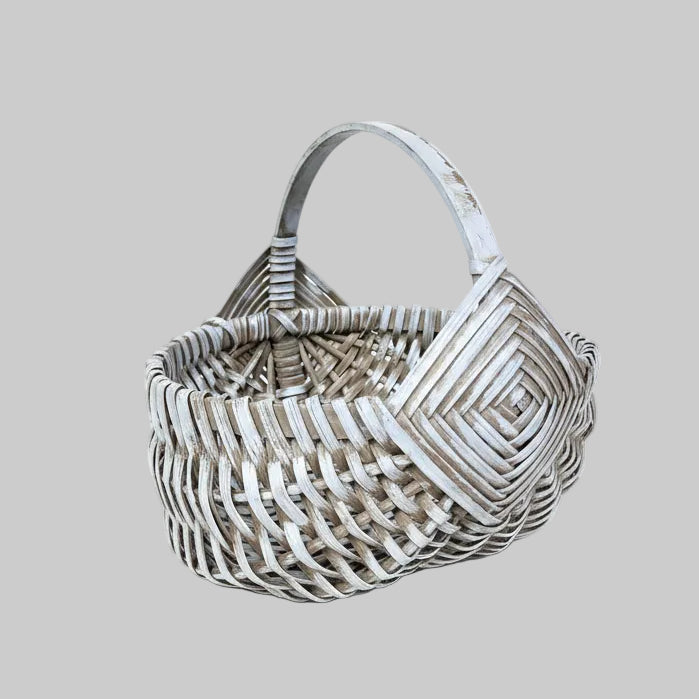 Woven basket on a wooden surface with green leaves
