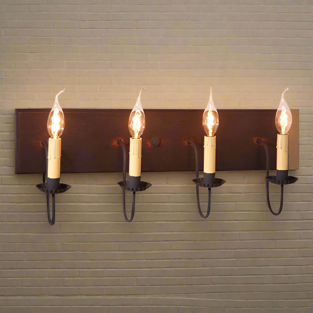A four-light vanity light fixture with a black over red finish, featuring textured arms with crimped pans and E12/Candelabra sockets.