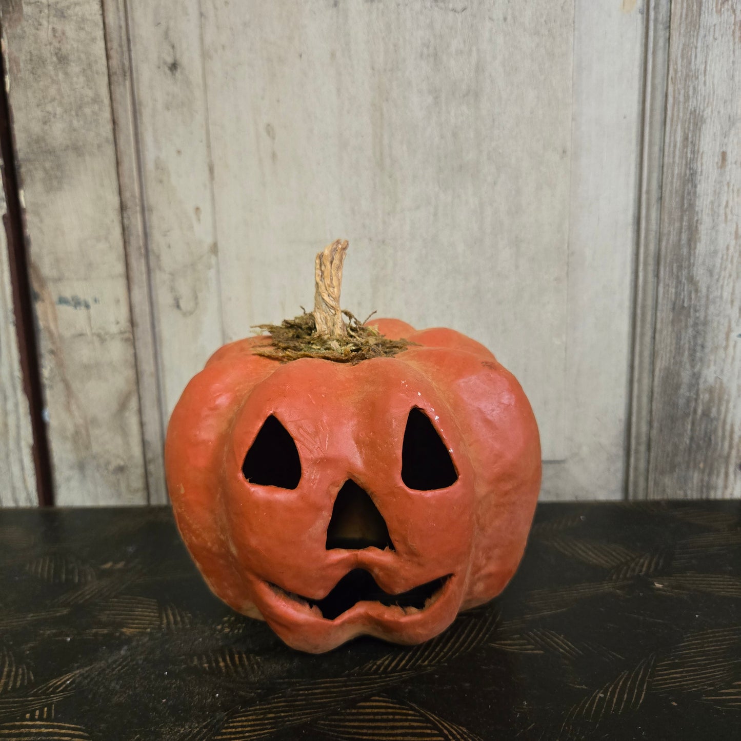 Carved pumpkin with a face on a wooden surface