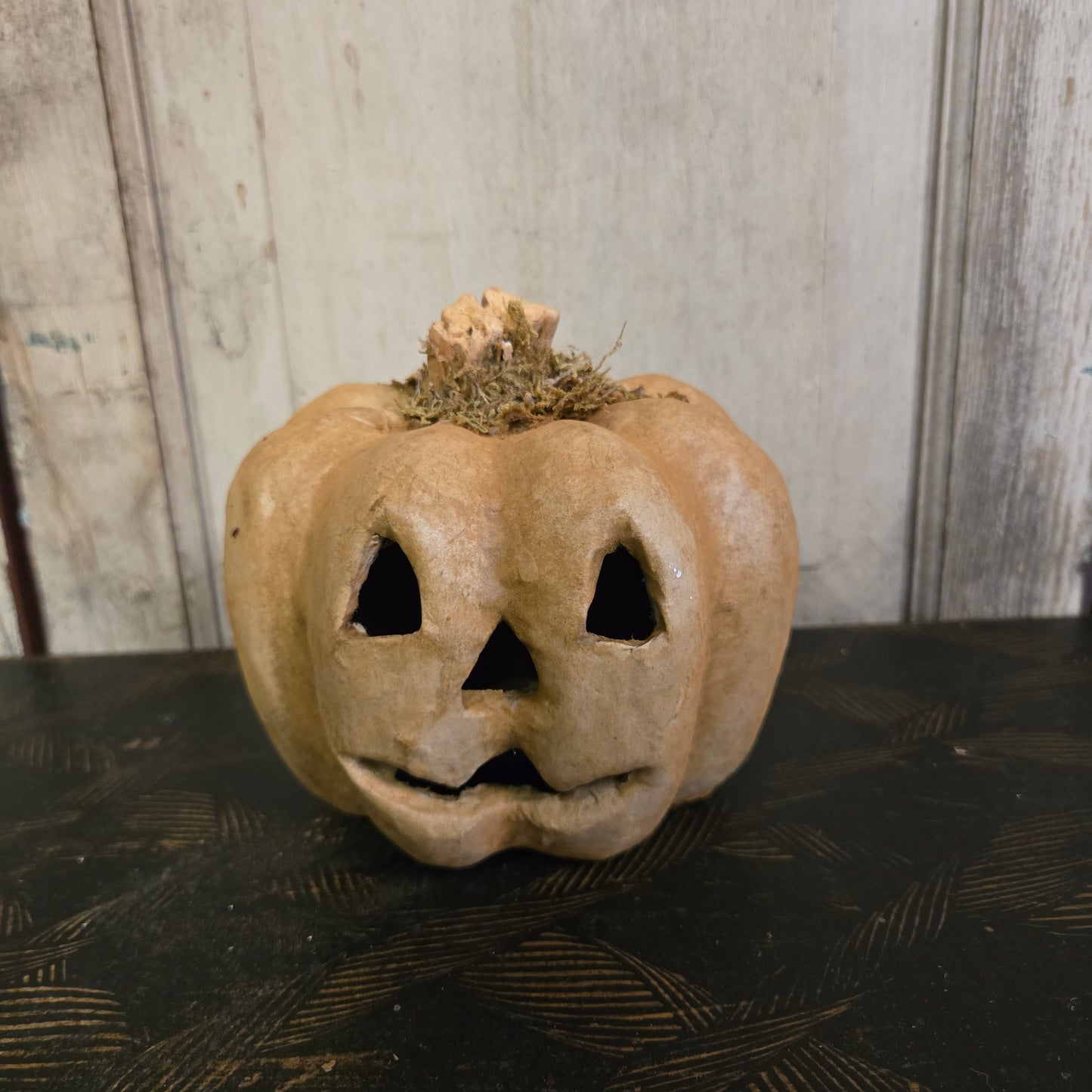 Carved pumpkin with a jack-o'-lantern face on a wooden surface