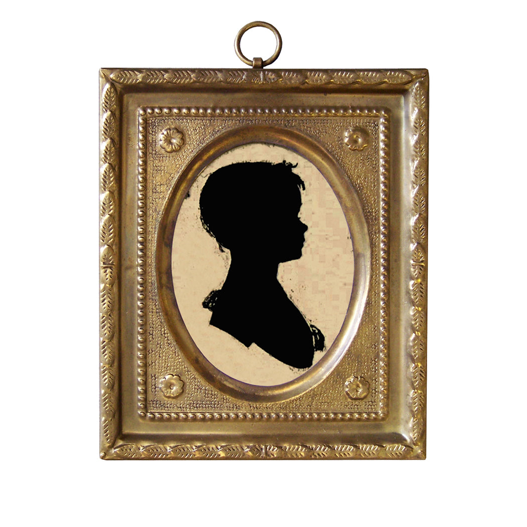 A brass frame miniature silhouette artwork depicting a girl, with a fabric backing.