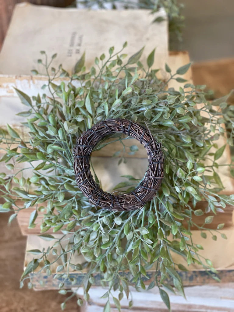 Green leafy wreath on a wooden surface with a rustic background