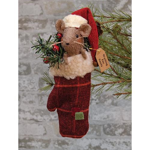 Primitive mouse in mitten wearing a Santa hat with greenery in background