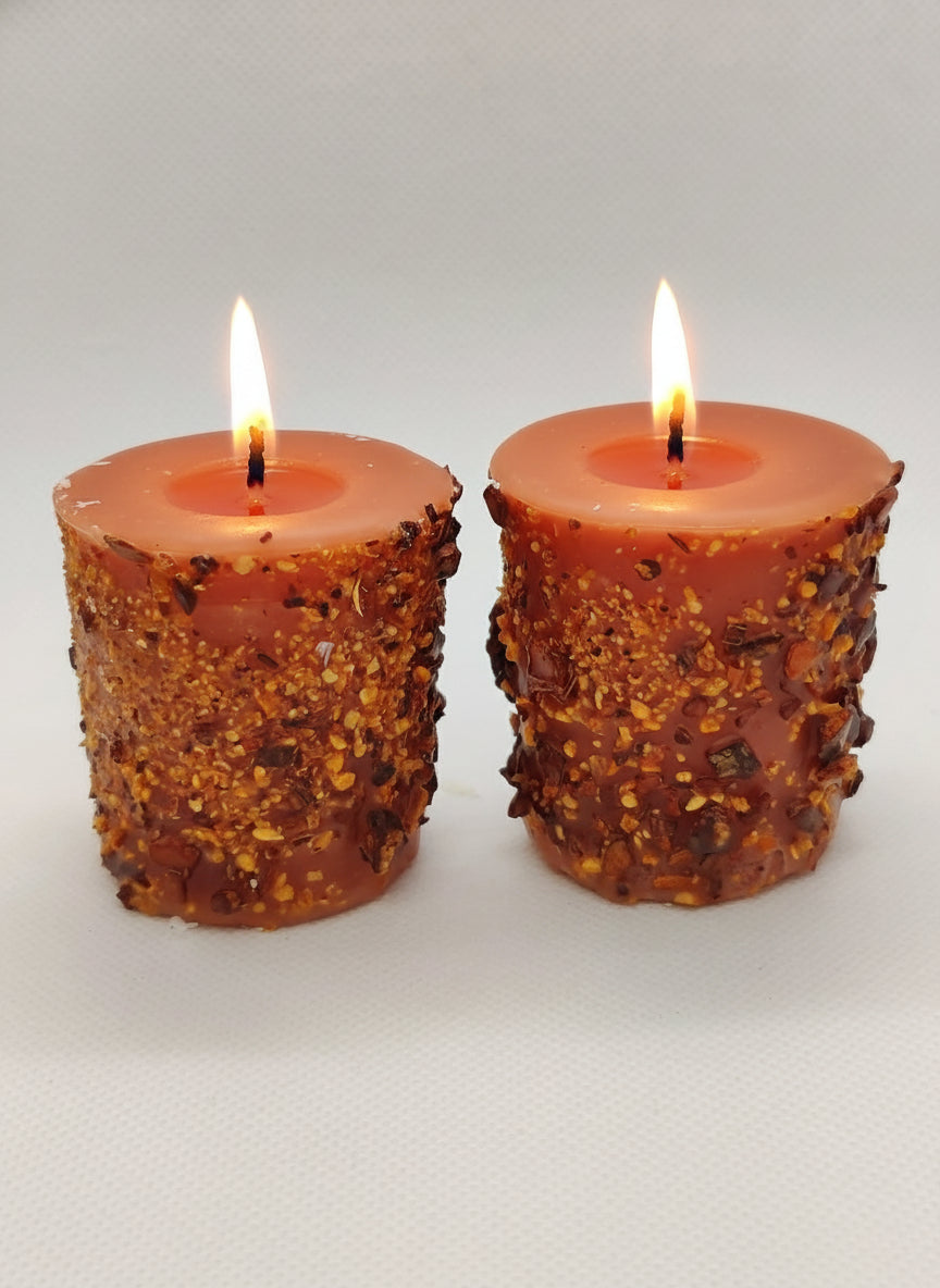 Two textured red candles on a white background