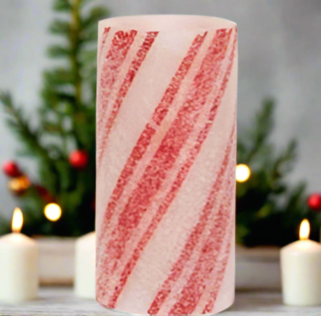 A battery-operated pillar candle with a warm glow, featuring a striped, red and white candy cane design, coated in glitter and icy frost.