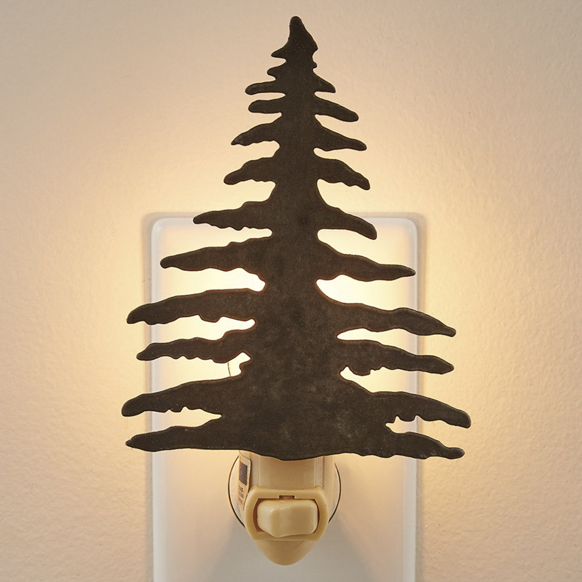 A night light that resembles a tree with a warm light emitting from the top, mounted on a wall.