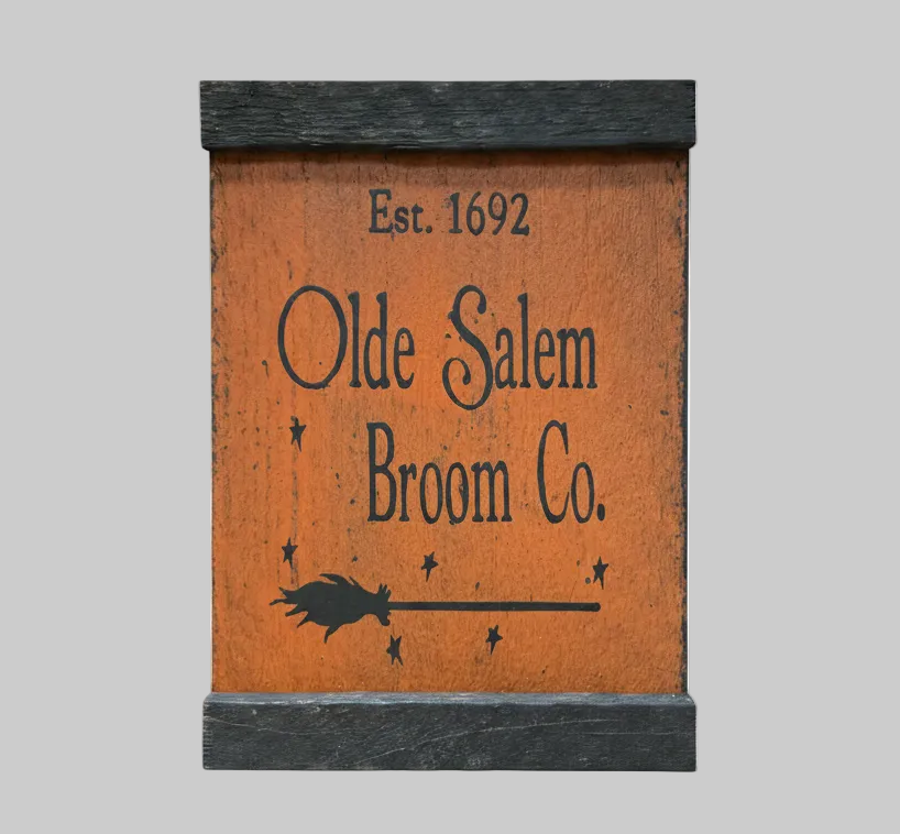 Wooden sign with 'Olde Salem Broom Co.' text and witch silhouette on a white background