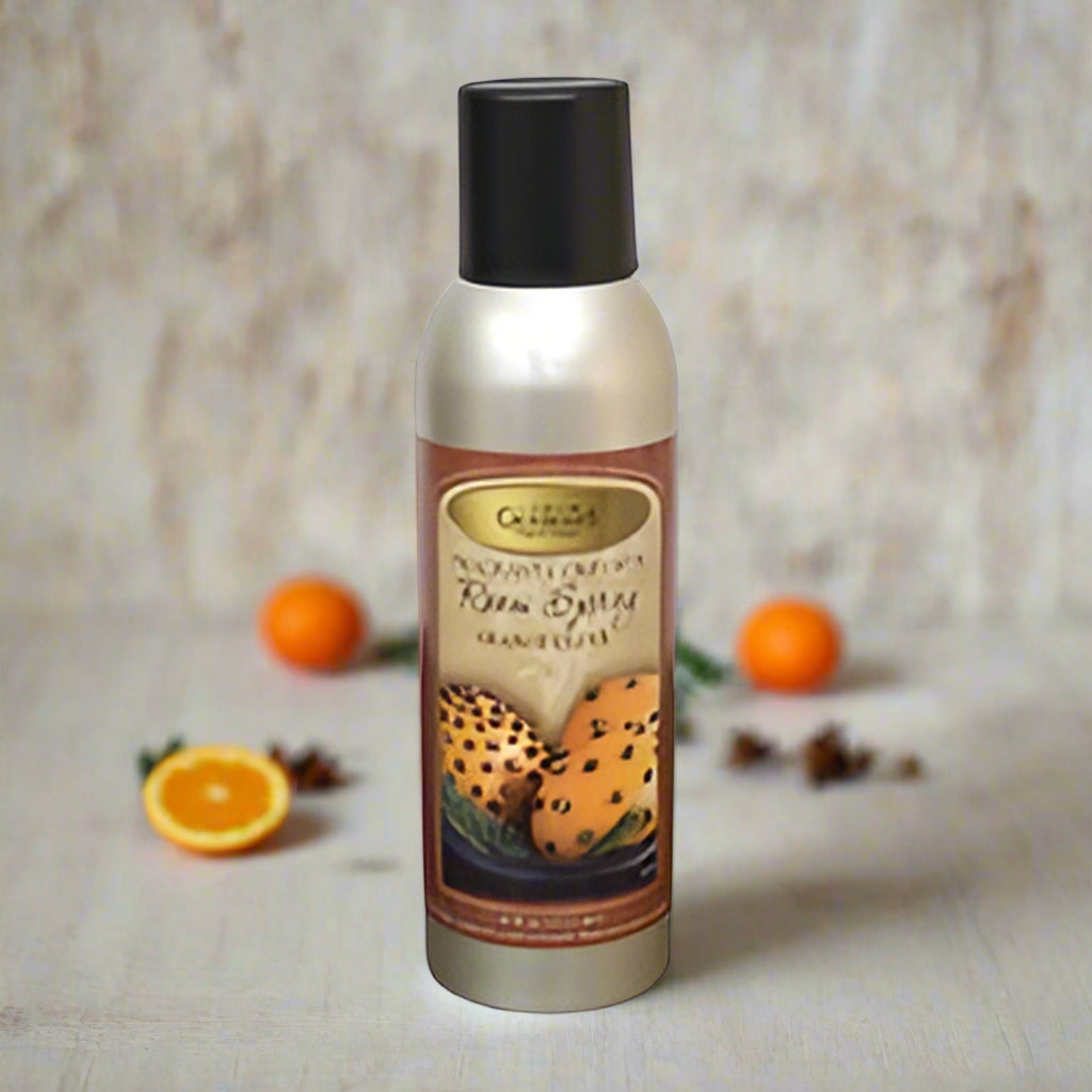 A bottle of Cayman's Orange Clove Room Spray with a black spray nozzle.