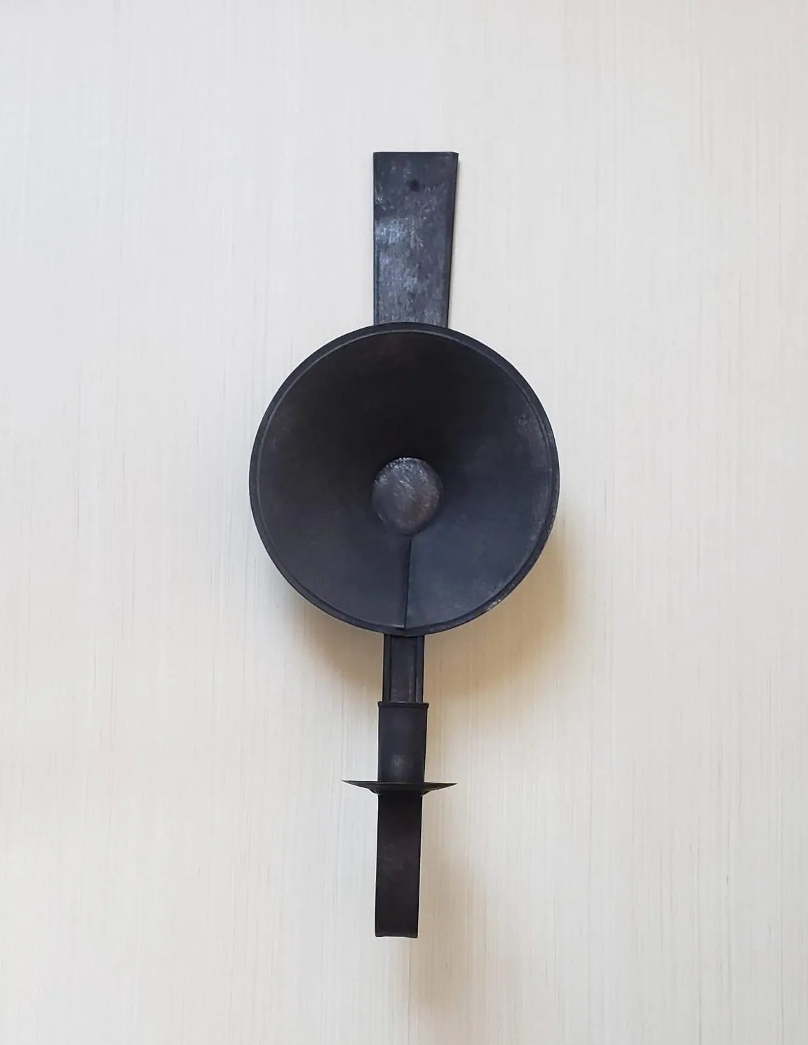 A black metal Patriot Mini Tin Sconce mounted on a wall.
